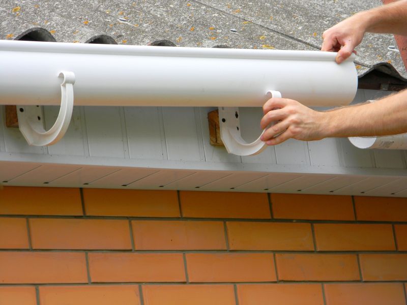 Service professionals inspecting gutters